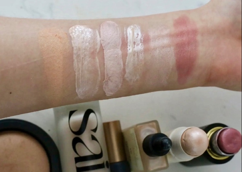 highlighter swatches of Inika Baked Illuminisor, Saie Super Glowy Gel, Inika Cream Illuminisor, Typology Glow Drops, Merit Highlighter Balm, Westman Atelier Highlight Stick